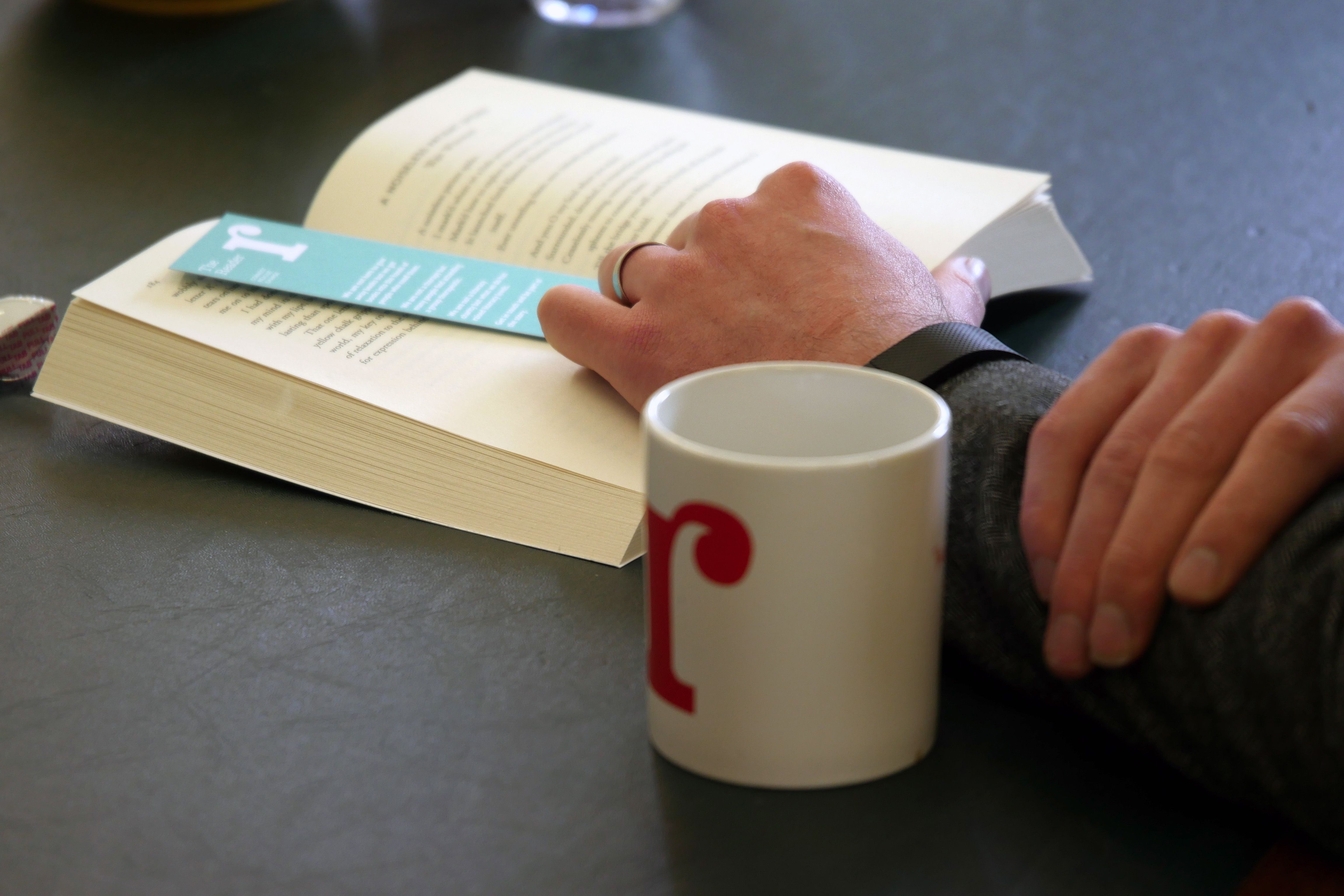 We love The Reader and take responsibility for it - an image of a hand in a book.