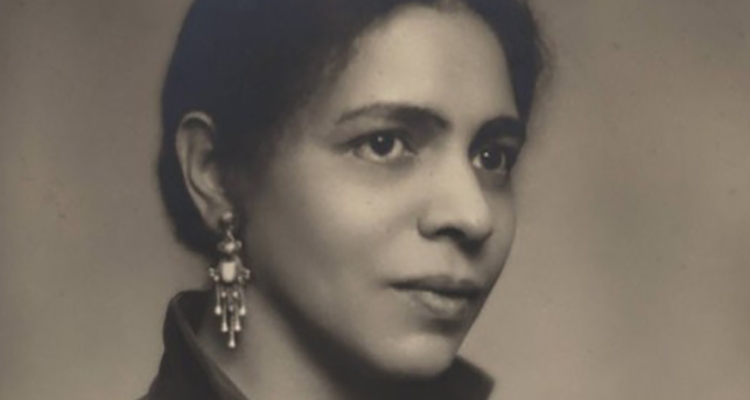 An image of the author Nella Larsen, she is wearing elegant earrings and has a neutral expression on her face