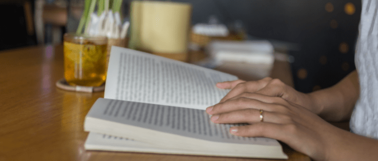 Hands resting on a book.