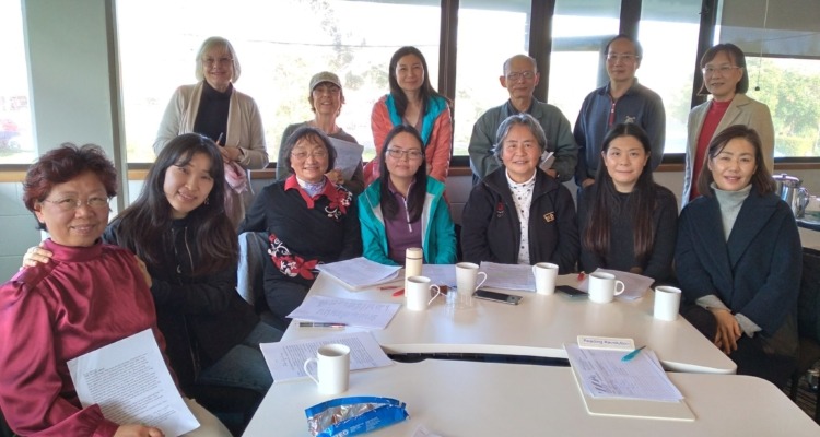 A group of people sitting around a table at Shared Reading group.