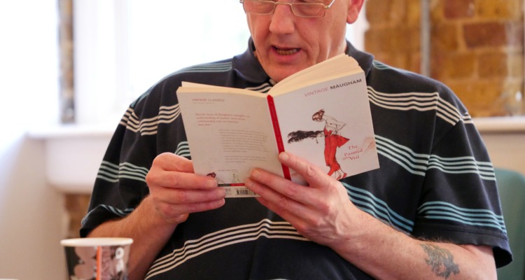 A man reading a book in a Shared Reading group.