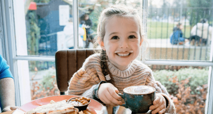 Little girl drinking hot chocolate in The Reader Cafe