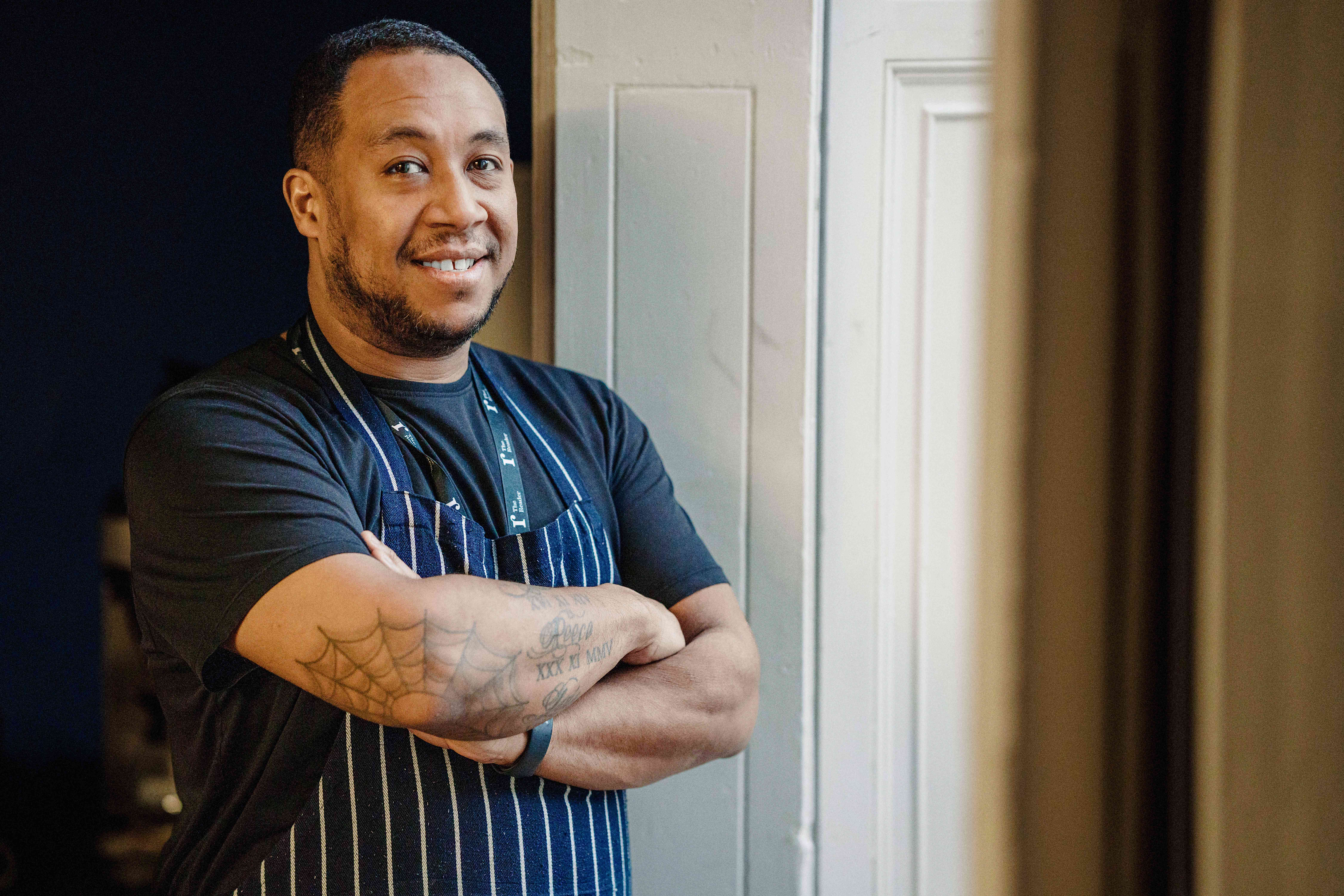 The Reader's head chef Jeff Gardner leans against a window frame and smiles at the camera