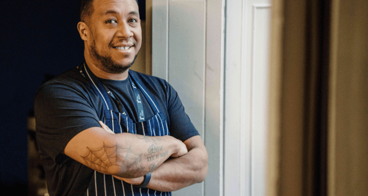 The Reader's head chef Jeff Gardner leans against a window frame and smiles at the camera