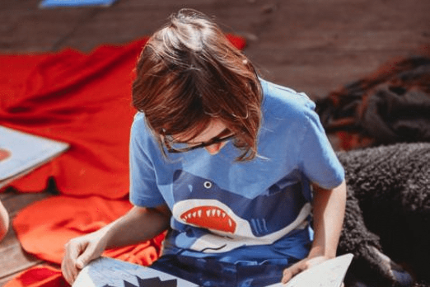 little boy in shark t-shirt reading