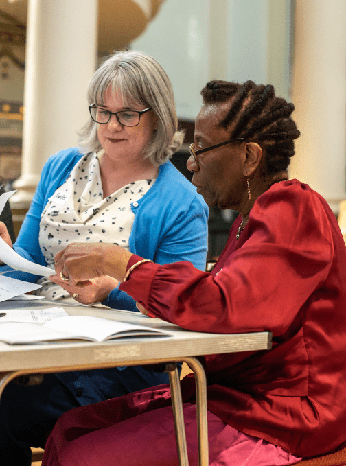 Two volunteers reading together at a support day